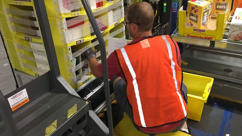 A worker loads products at the Amazon facility in Etna, Ohio. KARA DRISCOLL/STAFF