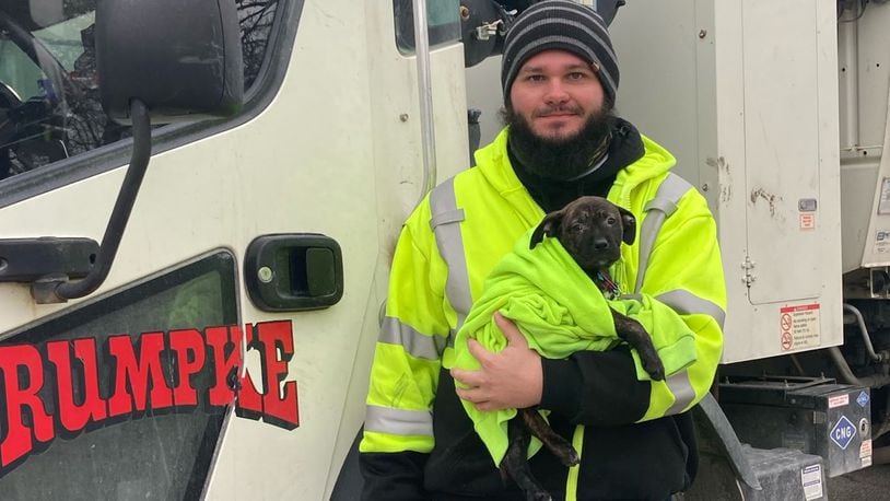 Aaron Kinsel of Hamilton rescued a puppy discarded in a backpack while on his Rumpke route Wednesday in Colerain Twp. SUBMITTED