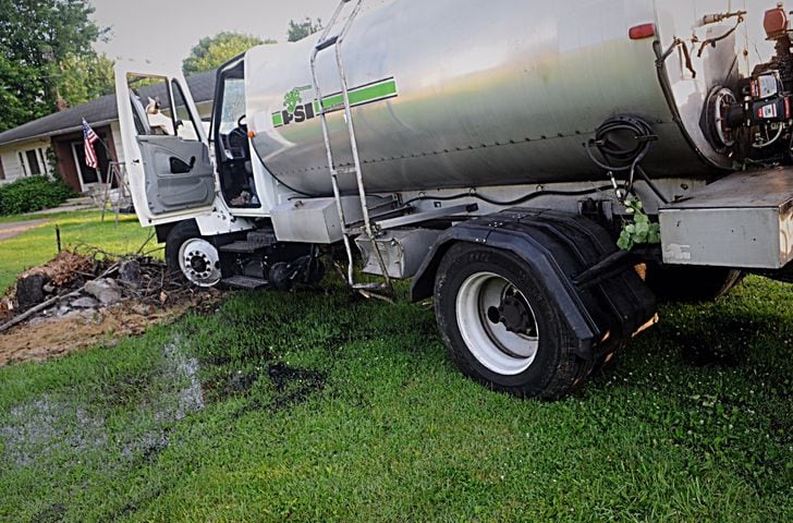 Tanker truck strikes pole, porch, other cars