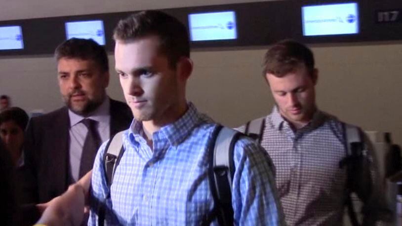 In this image made from video, American Olympic swimmers Gunnar Bentz and Jack Conger walk in the departure area after checking into their flight at the airport in Rio de Janeiro, Brazil, Thursday, Aug. 18, 2016. Brazilian police have said Ryan Lochte and three of his teammates were not robbed, and instead vandalized a gas station bathroom. Lochte had said earlier this week they were held up at gunpoint after a night of partying. (AP Photo)