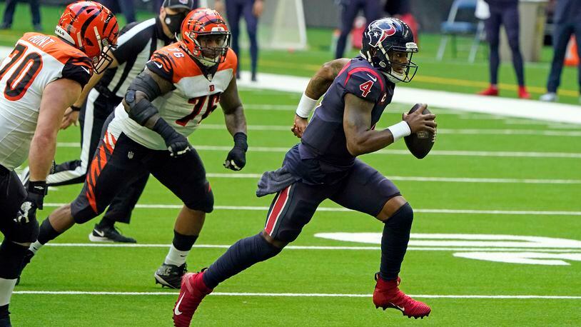 Houston Texans quarterback Deshaun Watson (4) rushes for a gain as Cincinnati Bengals' Margus Hunt (70) and Mike Daniels (76) defend during the second half of an NFL football game Sunday, Dec. 27, 2020, in Houston. (AP Photo/Eric Christian Smith)