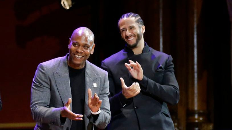 Comedian Dave Chappelle, left, and former NFL quarterback Colin Kaepernick, right, applaud during W.E.B. Du Bois Medal award ceremonies, Thursday, Oct. 11, 2018, at Harvard University, in Cambridge, Mass. Kaepernick and Chappelle are among eight recipients of Harvard University's W.E.B. Du Bois Medals in 2018. Harvard has awarded the medal since 2000 to people whose work has contributed to African and African-American culture.