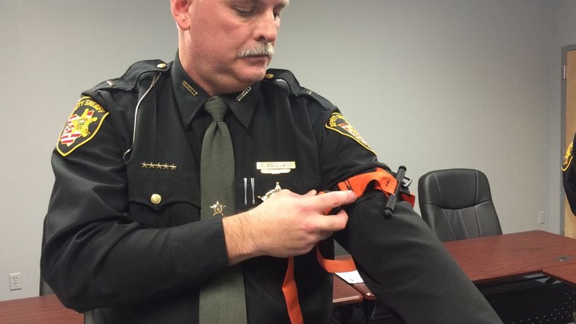 A Champaign County deputy demonstrates one of the new tourniquets they will carry. Katherine Collins/Staff