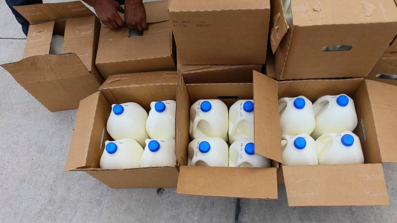 Boxes filled with gallons of milk are opened for distribution in this 2021 file photo from Brownsville, Texas.  (Denise Cathey/The Brownsville Herald via AP)