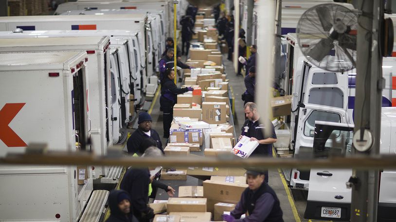 FILE - In this Dec. 15, 2014 file photo, packages are sorted on a conveyer belt before being loaded onto trucks for delivery at a FedEx facility in Marietta, Ga. (AP Photo/David Goldman, File)