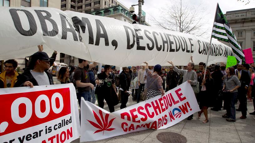 Demonstrators carry a mock marijuana cigarette as they march for the legalization of marijuana outside of the White House, in Washington on April 2, 2016. During the march they demanded Obama use his authority to stop marijuana arrests and pardon offenders.