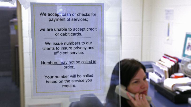 A sign on the reception window at the Clark County Combined Health District lets people know they only are accepting cash or checks now. Bill Lackey/Staff