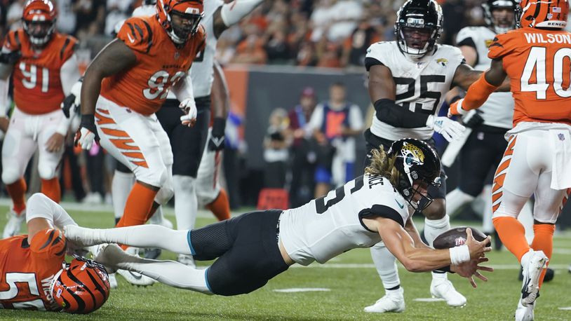 Jacksonville Jaguars quarterback Trevor Lawrence (16) dives in for touchdown while being tackled by Cincinnati Bengals' Logan Wilson (55) during the first half of an NFL football game, Thursday, Sept. 30, 2021, in Cincinnati. (AP Photo/Michael Conroy)