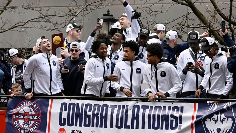 UConn players ride on a double decker bus during a parade to celebrate the team's NCAA college basketball championship, Saturday, April 13, 2024, in Hartford, Conn. (AP Photo/Jessica Hill)