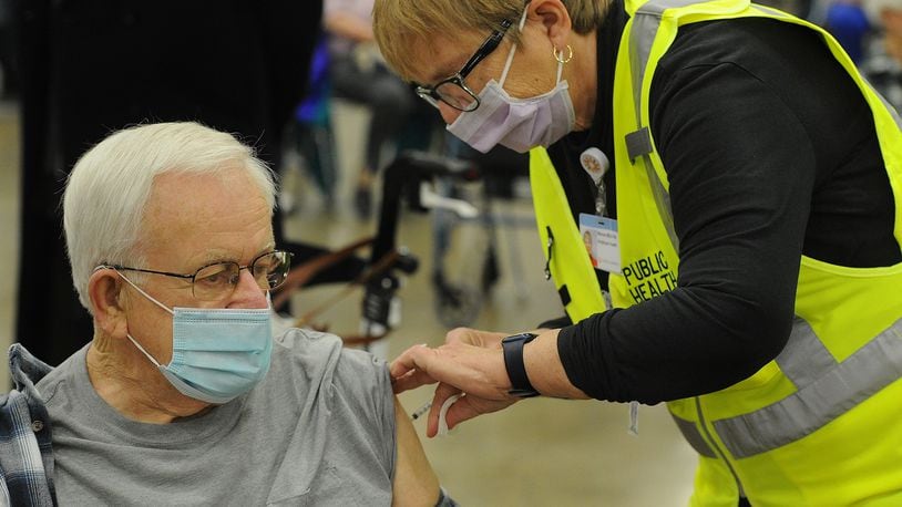 Michael Whitesell, 81, of Englewood, receives his COVID-19 vaccination from a healthcare worker Wednesday morning, Jan. 20, 2021 at the Dayton Convention Center. MARSHALL GORBY\STAFF