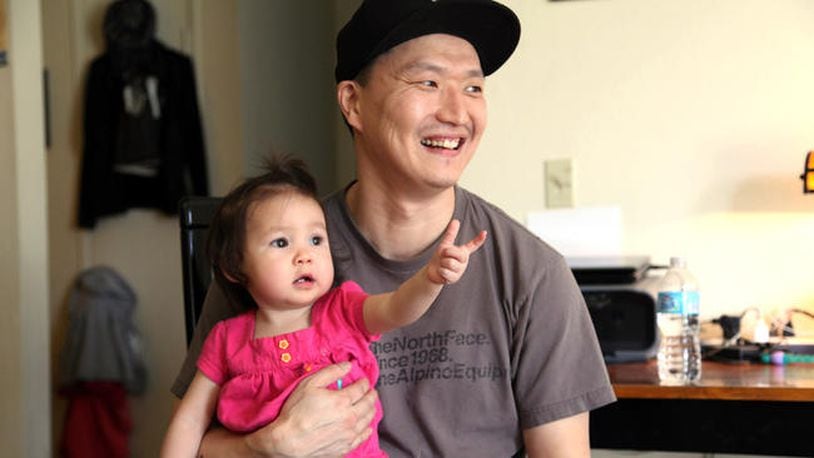 South Korean adoptee Adam Crapser poses with daughter Christal in the family's living room in Vancouver, Wash., in March 2015.
