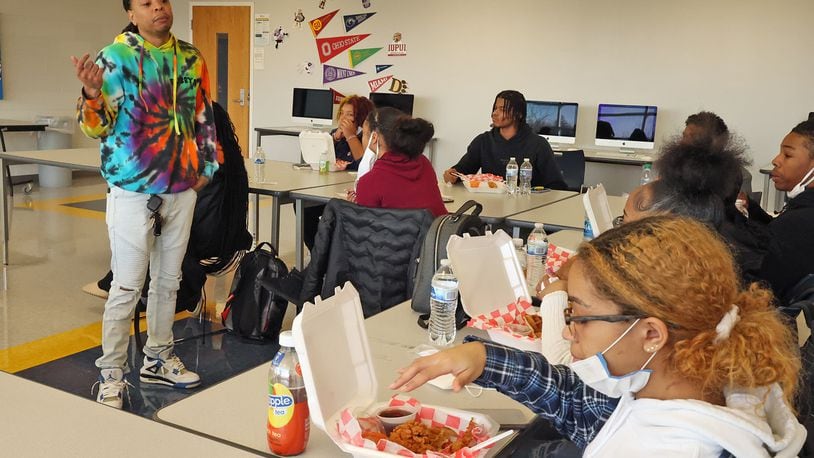 Kareem Crossley, the owner of Bubby's Chicken & Waffles, talks to a group of Springfield High School students about the rewards and struggles of starting your own business Thursday as they enjoy the chicken and waffle meals he brought for them. BILL LACKEY/STAFF