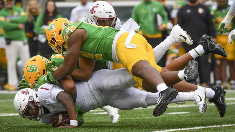 Washington State quarterback Cameron Ward (1) is sacked by Oregon linebackers Jestin Jacobs, center, and Blake Purchase, top, during the second half of an NCAA college football game Saturday, Oct. 21, 2023, in Eugene, Ore. (AP Photo/Andy Nelson)