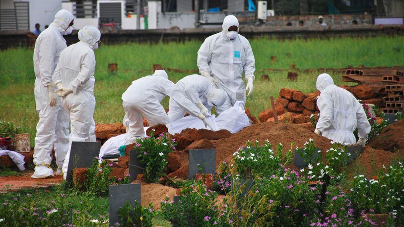 In this Thursday, May 24, 2018, photo, paramedics wear protective suits as a precautionary measure against the Nipah virus as they bury a victim of the deadly disease in the southern Indian state of Kerala. More than 10 people have died of Nipah since an outbreak began earlier this month in Kerala, health officials say.