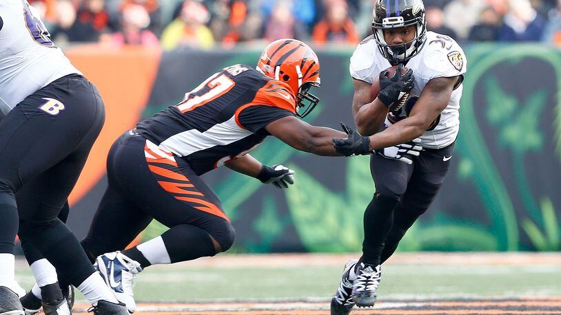 CINCINNATI, OH - JANUARY 1: Kenneth Dixon #30 of the Baltimore Ravens breaks an attempted tackle by Geno Atkins #97 of the Cincinnati Bengals during the third quarter at Paul Brown Stadium on January 1, 2017 in Cincinnati, Ohio. (Photo by Michael Hickey/Getty Images)