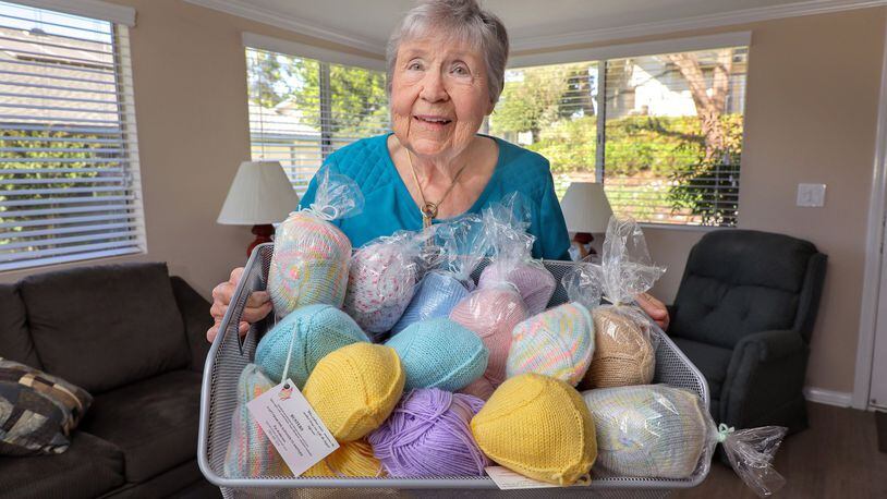Pat Anderson holds a basket full of her various “Busters” wardrobe accessories for breast cancer survivors. (Charlie Neuman/San Diego Union-Tribune/TNS)