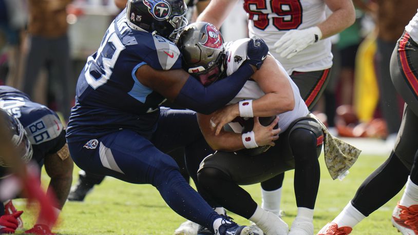 Tennessee Titans defensive tackle Teair Tart, left, sacks Tampa Bay Buccaneers quarterback Baker Mayfield, right, during the first half of an NFL football game Sunday, Nov. 12, 2023, in Tampa, Fla. (AP Photo/Chris O'Meara)