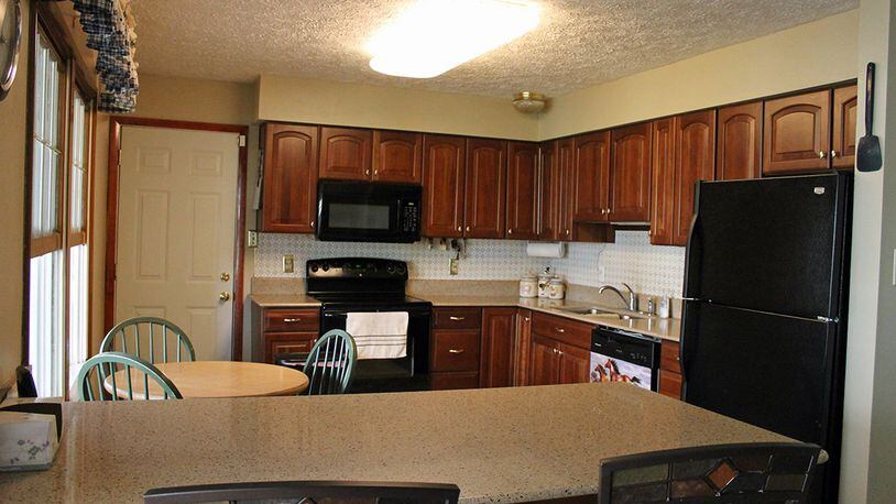 Features of the kitchen include a breakfast bar and plenty of cherry cabinetry.