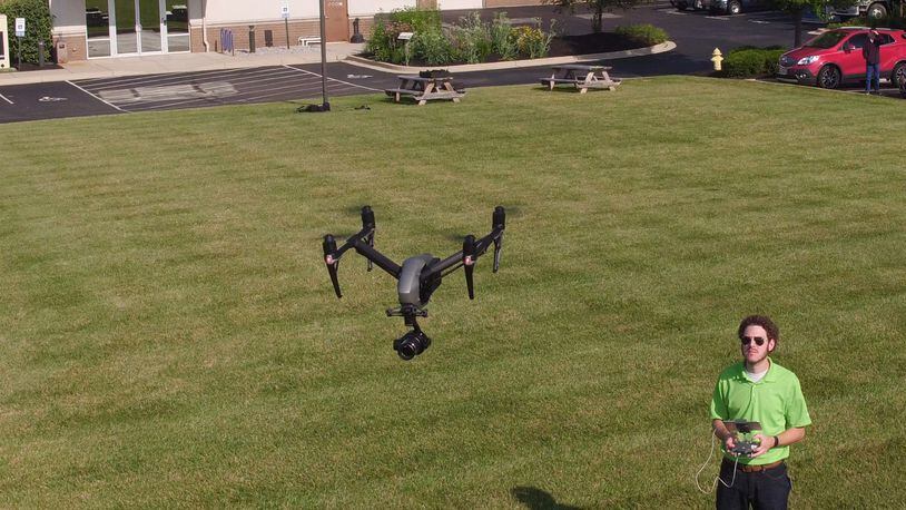 Ethan Schreuder, a survey technician and UAS pilot for Beavercreek-based Woolpert, flies a company unmanned aerial vehicle. Using drones for mapping and surveying has become a part of the company’s daily business. TY GREENLEES / STAFF