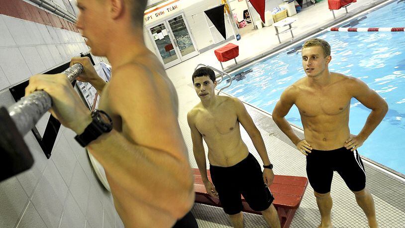 Josh Rotroff, center, and Seth Payton encourage their friend, Andy Lawson, to knock out more pull-ups on a bar at the Springfield YMCA before they start swimming laps. The three Springfield friends have worked out together at the YMCA and will soon leave one after another for Air Force special operations training. Bill Lackey/Staff