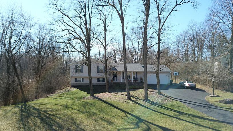 The quad-level home sits on a wooded 1-plus acre lot and the front features a covered porch and two-car attached garage. Contributed photos