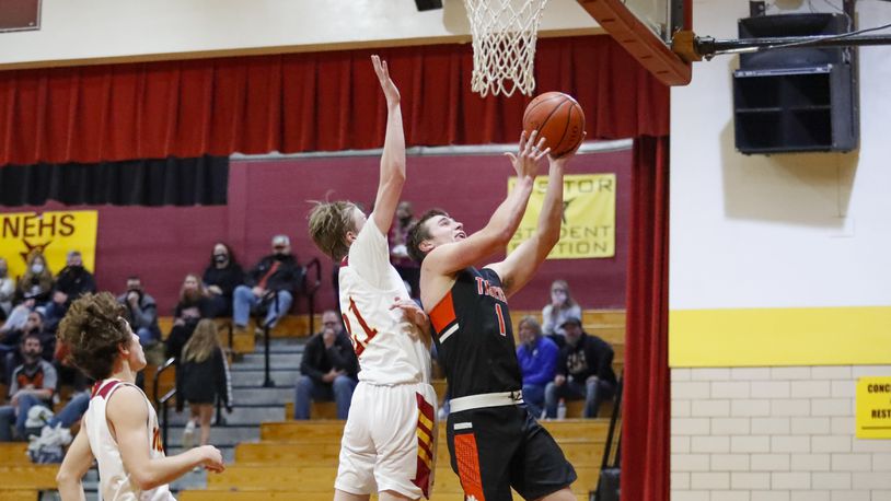 WLSbbk1: West Liberty-Salem High School senior Nick Burden shoots a layup over Northeastern's Adam Webb during their game on Tuesday night in Springfield. The Tigers won 65-45. CONTRIBUTED PHOTO BY MICHAEL COOPER
