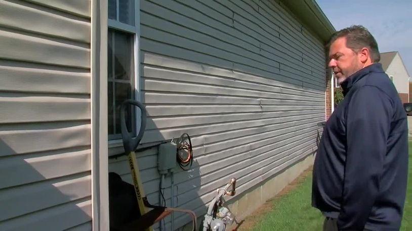 Homeowner Randy Scarth looks over the warped vinyl siding on the side of his house. A home inspector told them it is due to concentrated sunlight from a neighbor's window, a problem that worsens in the winter when the sun is low in the sky. WCPO