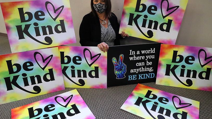 Kristy Thome, Administrative Assistant/Clerk of Courts for Enon, with the "Be Kind" signs she came up with Thursday. BILL LACKEY/STAFF