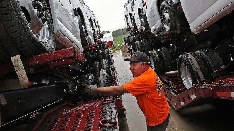 Charlie Johnson, a truck driver with Wheeler Trucking, checks the GM trucks he was hauling from the Navistar plant in Springfield Tuesday. Demand for new class 8 trucks, the kind sold by Navistar, is far outpacing the capacity for manufacturers to keep up, according to analysts. BILL LACKEY/STAFF