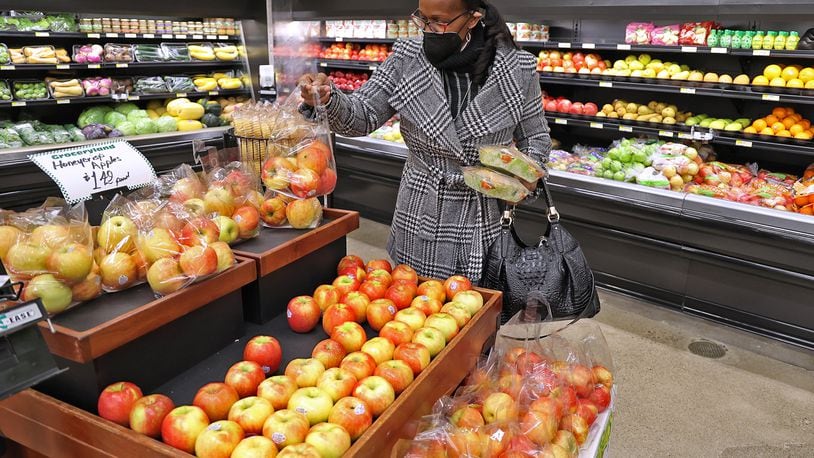 Nettie Carter-Smith picks up some fresh fruits and vegetables in December at the new Groceryland store on South Limestone Street. The grocery store will be donating this year's profits to community efforts. BILL LACKEY/STAFF