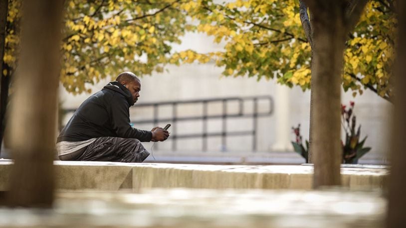 Darien Crowe, from Dayton, texts his girlfriend Tuesday October 13, 2020 on Courthouse Square. Dayton, Yellow Spring and Springboro are cities that are putting in free WIFI in part of their cities. FILE