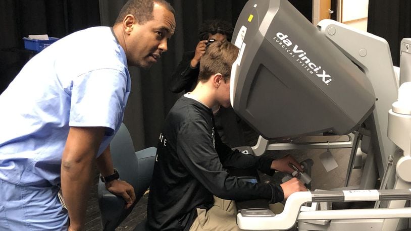 Graham Middle School student Josh Still tests a virtual operating system from Urbana Hospital with the guidance of surgeon Tedros Androm, MD. LUCAS GONZALEZ/STAFF