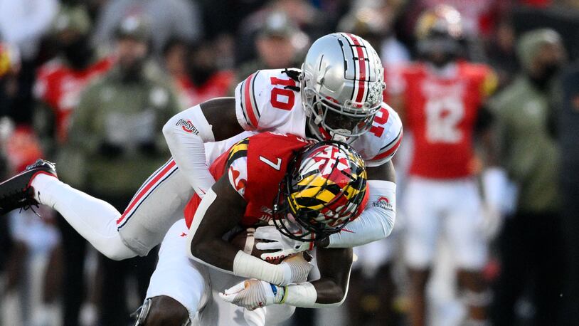 Ohio State cornerback Denzel Burke (10) tackles Maryland wide receiver Dontay Demus Jr. (7) during the first half of an NCAA college football game, Saturday, Nov. 19, 2022, in College Park, Md. (AP Photo/Nick Wass)