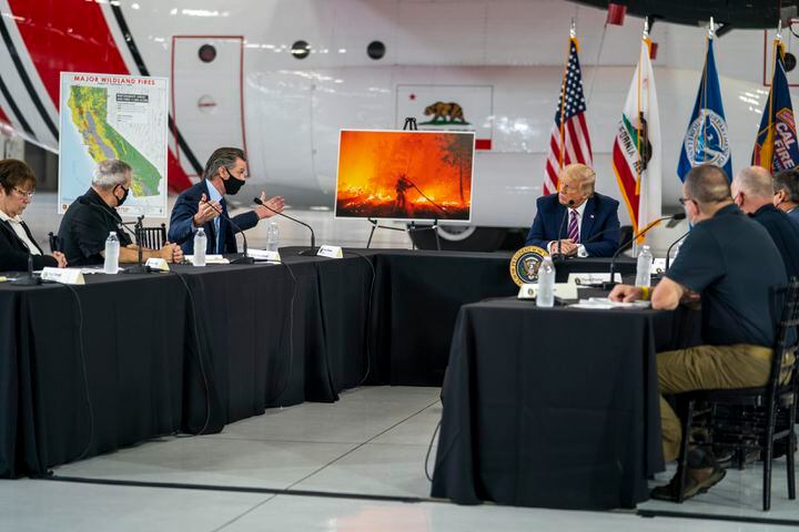 Gov. Gavin Newsom of California, second from left, and President Donald Trump during a briefing about the state’s wildfires at the Sacramento McClellan Airport in McClellan Park, Calif., Sept. 14,  2020. President Trump visited California after weeks of silence on its wildfires and blamed the crisis only on poor forest management, not climate change. (Doug Mills/The New York Times)