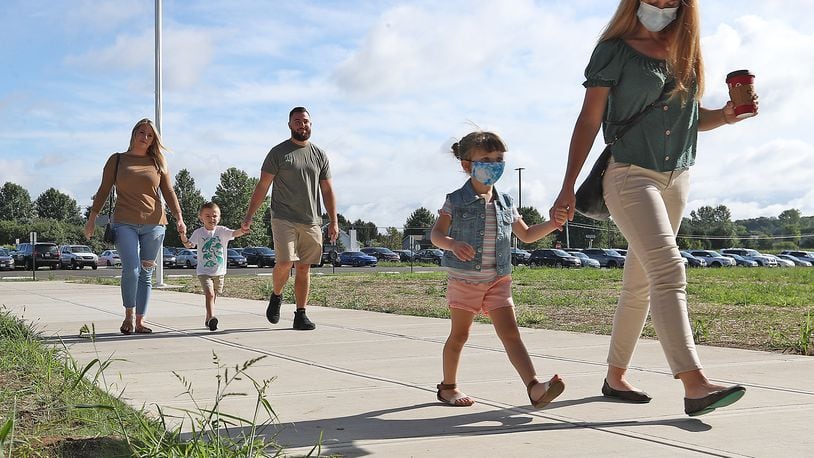 Preschool and kindergarten students walk into Shawnee Elementary School with their parents last fall. BILL LACKEY/STAFF