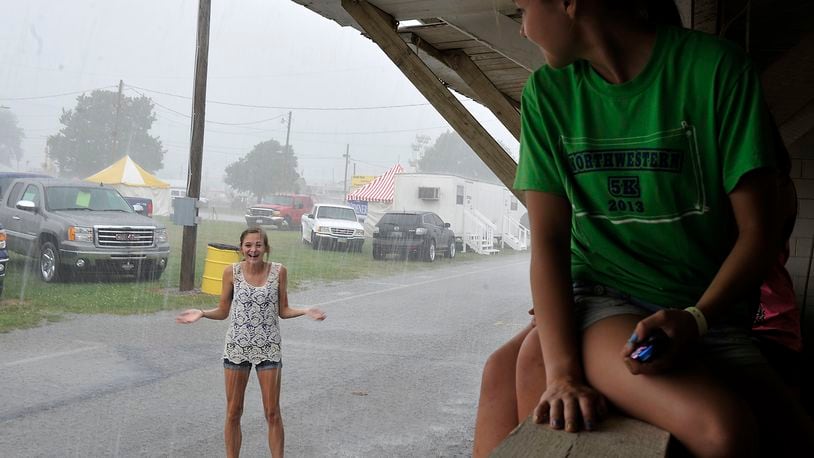 Elly Grimm, 14, plays in the rain Friday at the Clark County Fair as her friends watch her from a window in a dry barn. Bill Lackey/Staff
