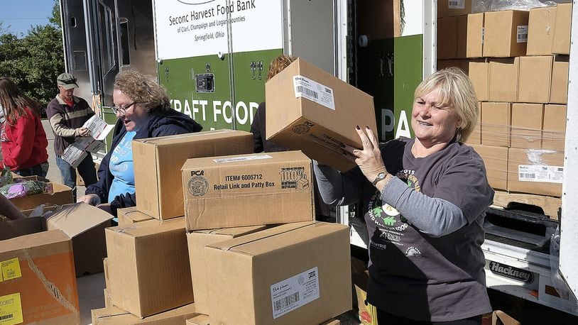 Volunteers unload food from the Second Harvest Food Bank’s Mobile Food Pantry. BILL LACKEY/STAFF