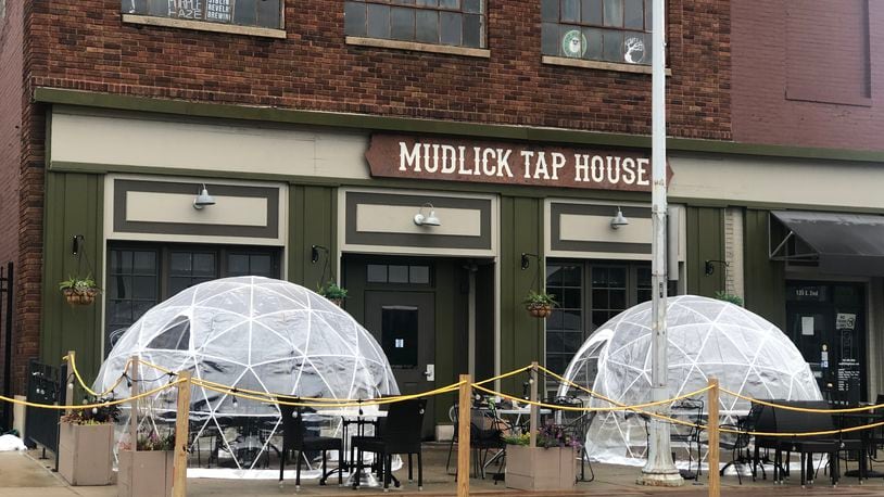 Mudlick Tap House in downtown Dayton installed plastic igloos on its patio to keep guests safe during the pandemic. CORNELIUS FROLIK / STAFF