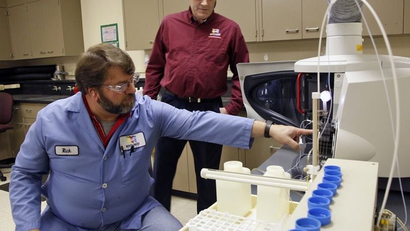 Lab Analyst Rick Pennington, left, and Lab Services Manager Jim Davis, Montgomery County Environmental Services, monitor a lead testing machine.  TY GREENLEES / STAFF