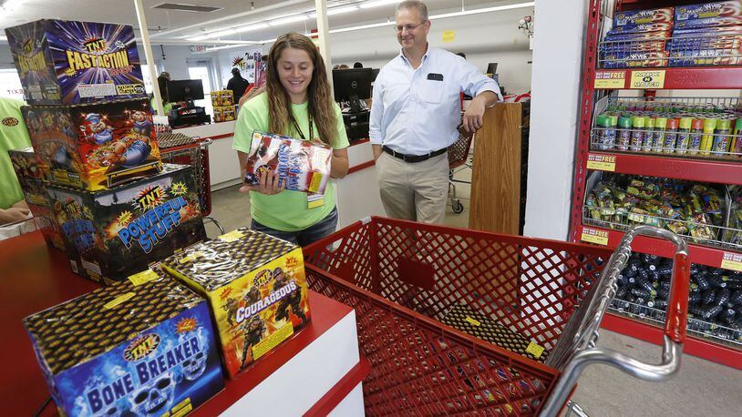 TNT Fireworks employee Courtney Evans, left, assists Christian Krupa on Tuesday afternoon as he loads up for an Independence Day celebration. TY GREENLEES / STAFF