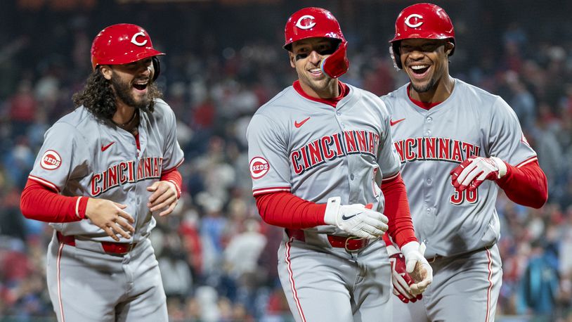 Cincinnati Reds' Spencer Steer, center, celebrates his grand slam with Jonathan India, left, and Will Benson during the tenth inning of a baseball game against the Philadelphia Phillies, Monday, April 1, 2024, in Philadelphia. (AP Photo/Chris Szagola)