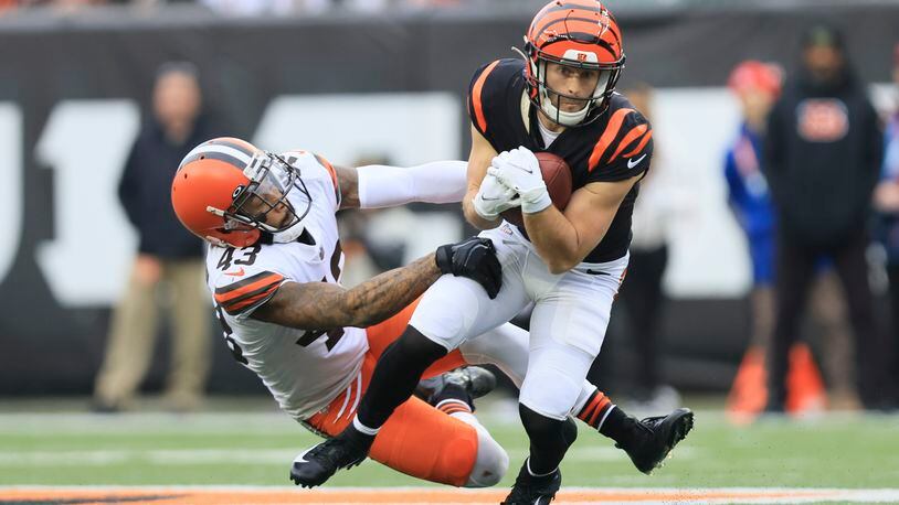 Cincinnati Bengals' Trent Taylor (11) runs out of a tackle of Cleveland Browns' John Johnson III (43) during the first half of an NFL football game, Sunday, Dec. 11, 2022, in Cincinnati. (AP Photo/Aaron Doster)