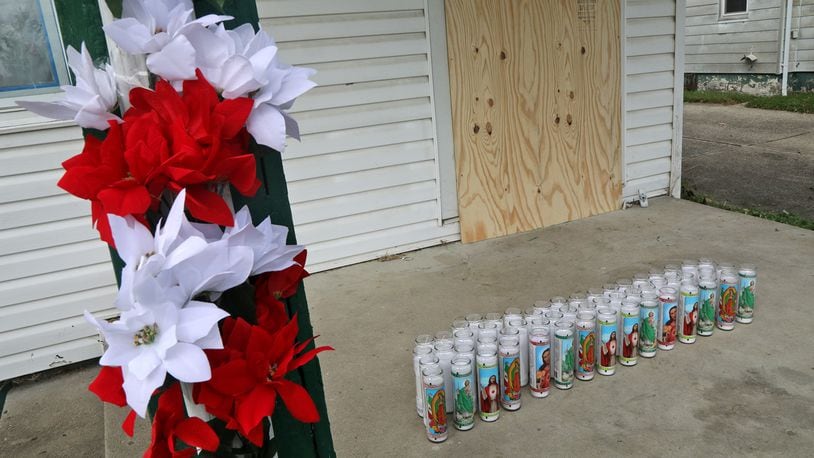 A memorial, made up of flowers and candles, has been made on the front porch at 41 North Douglas Avenue where the body of  Gloria Dickinson was discovered Wednesday. BILL LACKEY/STAFF