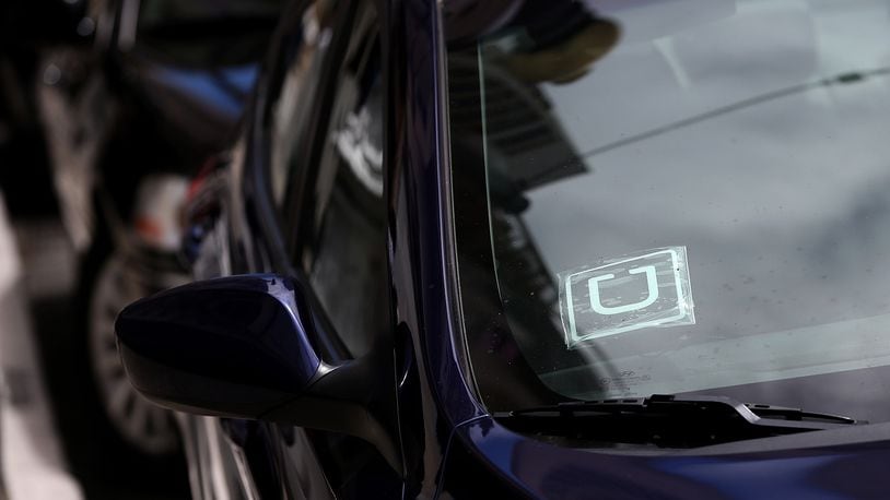 A sticker with the Uber logo is displayed in the window of a car.  Atlanta police apprehended a 15-year-old girl after an Uber driver was car jacked when the teen and a man held him at gunpoint. (Photo by Justin Sullivan/Getty Images)