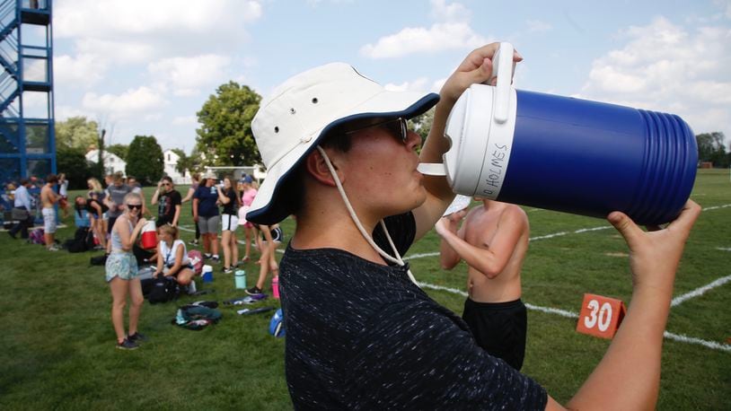 In Dayton on Monday afternoon, Fairmont High School Marching Firebirds sophomore tuba player Dustin Holmes, 15, takes a drink during practice. Temperatures throughout the region are expected to top 90 again Tuesday  with a heat index of 95 to 100. (Ty Greenlees/Staff)