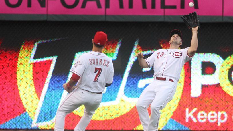 Reds right fielder Adam Duvall, right, makes a catch as shortstop Eugenio Suarez watches against the Cardinals on Wednesday, June 8, 2016, at Great American Ball Park in Cincinnati. David Jablonski/Staff