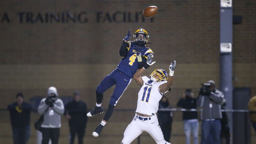 Springfield High School junior Daylen Bradley leaps over Cincinnati Moeller's Rashad Glenn to catch a touchdown pass during a D-I state semifinal game on Friday night at Sidney Memorial Stadium. The Wildcats won 22-21. Michael Cooper/CONTRIBUTED