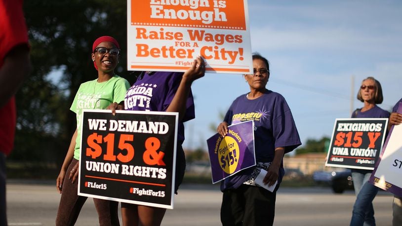 MIAMI, FL - APRIL 14: Demonstrators protest together as they demand an increase in the minimum wage to $15 an hour on April 14, 2016 in Miami, Florida. The demonstrators, some of whom were some of the thousands of caregivers striking at 19 Consulate-owned nursing homes throughout the state, marched together to a McDonald's restaurant, as they take part in a day-long effort to draw attention to low-wage jobs. The demonstration was one of about 300 scheduled to take place nationwide today (Photo by Joe Raedle/Getty Images)