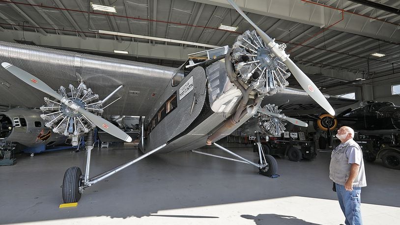 Ernie Holbrook looks over the 1928 Ford Tri-Motor airplane Thursday in the museum hanger at Grimes Field in Urbana. The historic airplane, the first airliner to be mass produced, will be based at Grimes Field this weekend and taking people for rides between 9am and 5pm through Sunday. BILL LACKEY/STAFF
