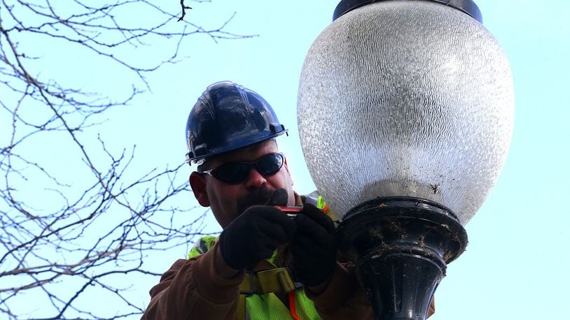 Shane Delaet, an employee with the City of Springfield Service Department, works on a street light along Fountain Avenue Friday. The city of Springfield may go back on the ballot in May, but some commissioners are undecided about the idea. Bill Lackey/Staff